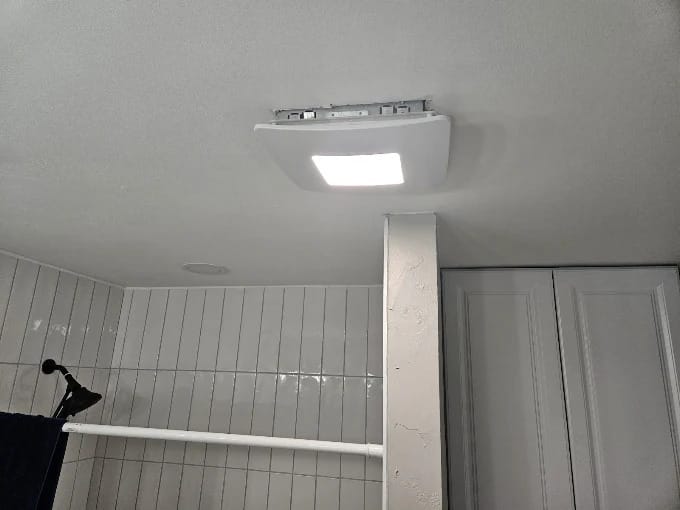 Bathroom remodel with large white wall tile, hexagon floor tile and a new toilet