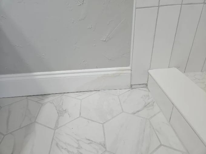 Bathroom remodel with large white wall tile, hexagon floor tile and a new toilet