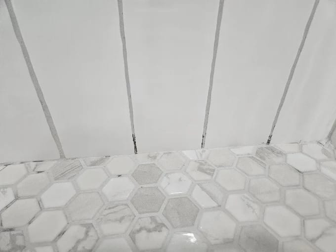 Bathroom remodel with large white wall tile, hexagon floor tile and a new toilet