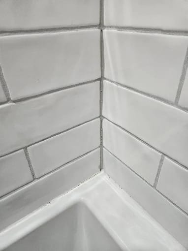 Bathroom remodel with large white wall tile, hexagon floor tile and a new toilet