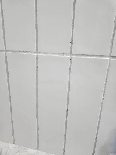 Bathroom remodel with large white wall tile, hexagon floor tile and a new toilet