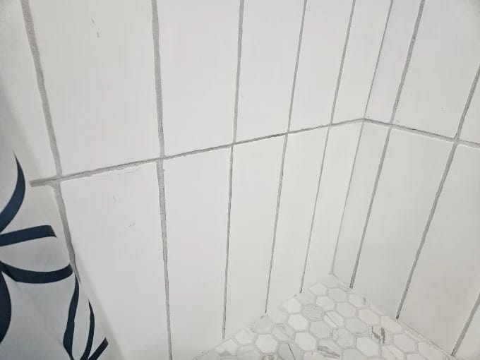 Bathroom remodel with large white wall tile, hexagon floor tile and a new toilet