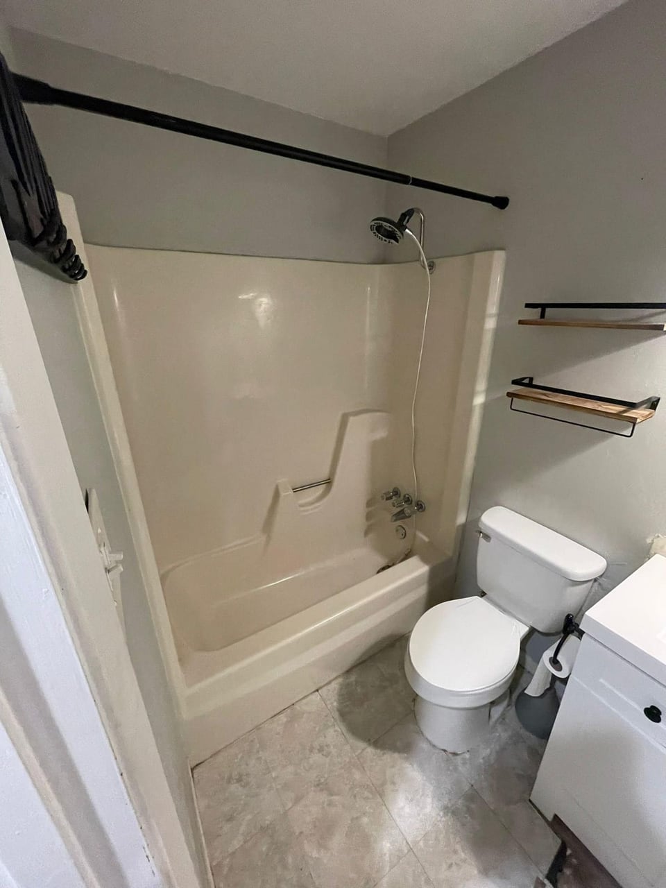 Bathroom tub and shower remodel with white subway tile and matte black fixtures